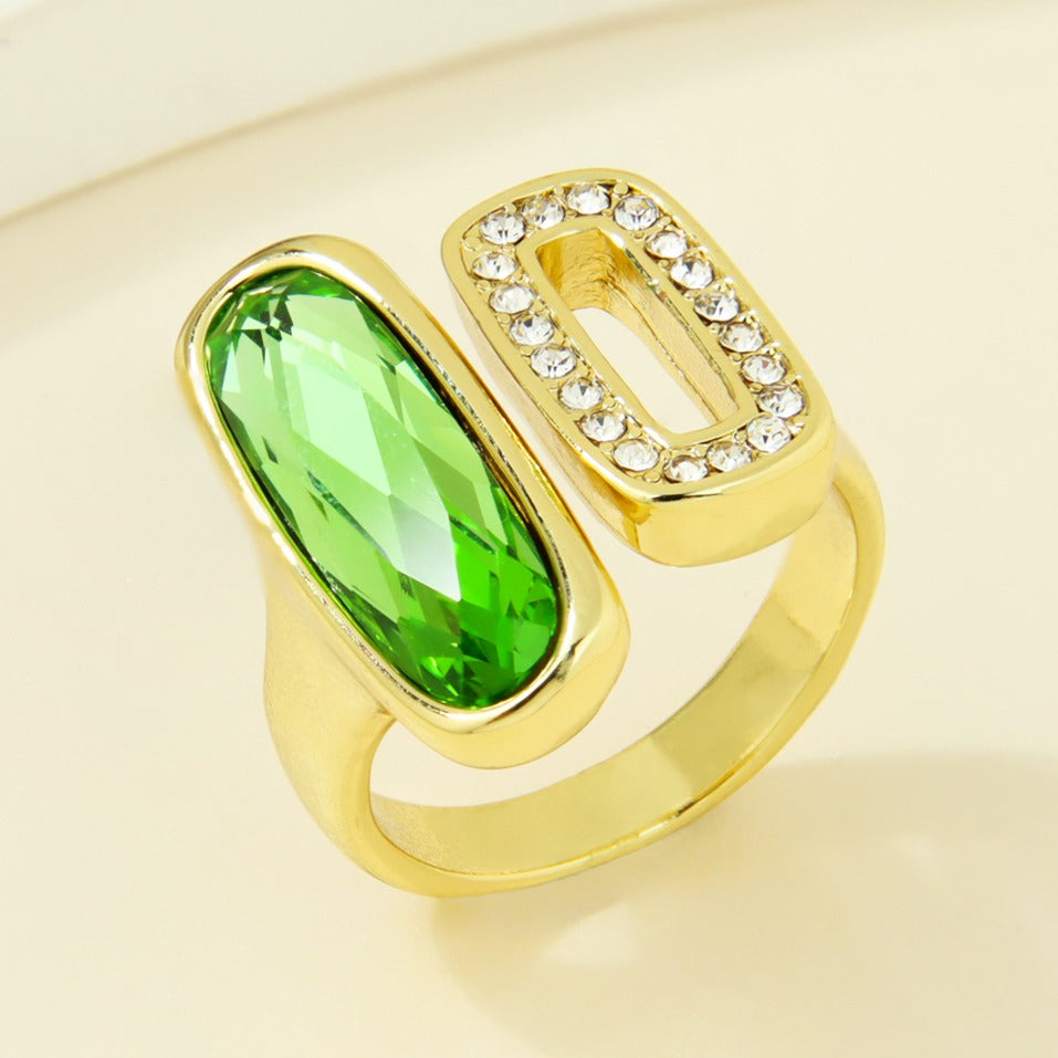 Gold-plated statement ring with a green oval accent and clear rectangular detail
