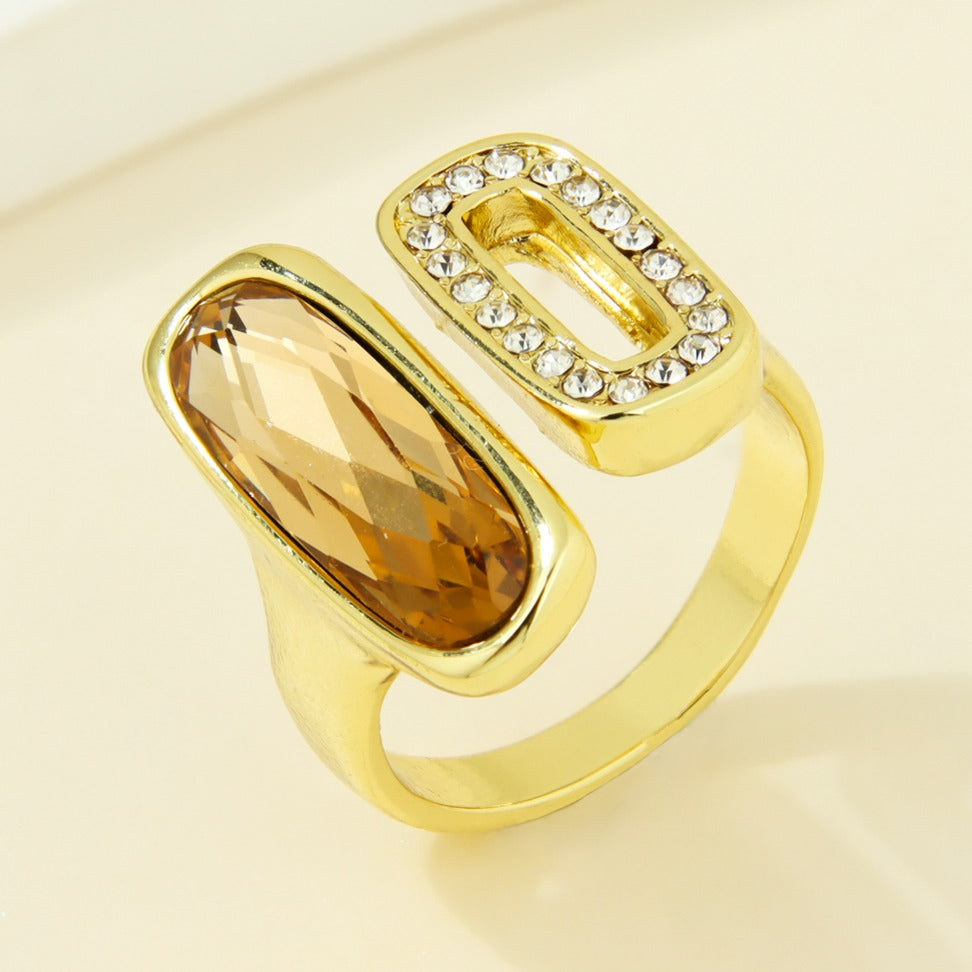 Gold-plated statement ring with an amber-colored oval accent and clear rectangular detail