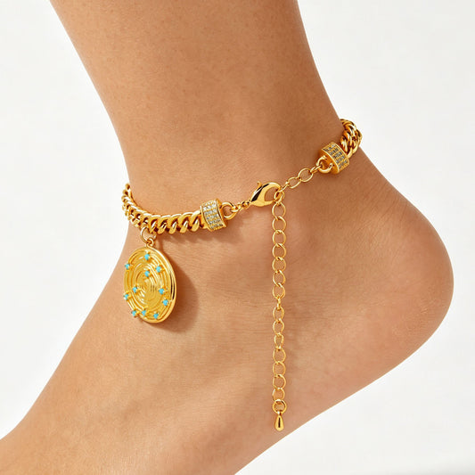 Gold-tone chain anklet with a round coin charm and blue accents